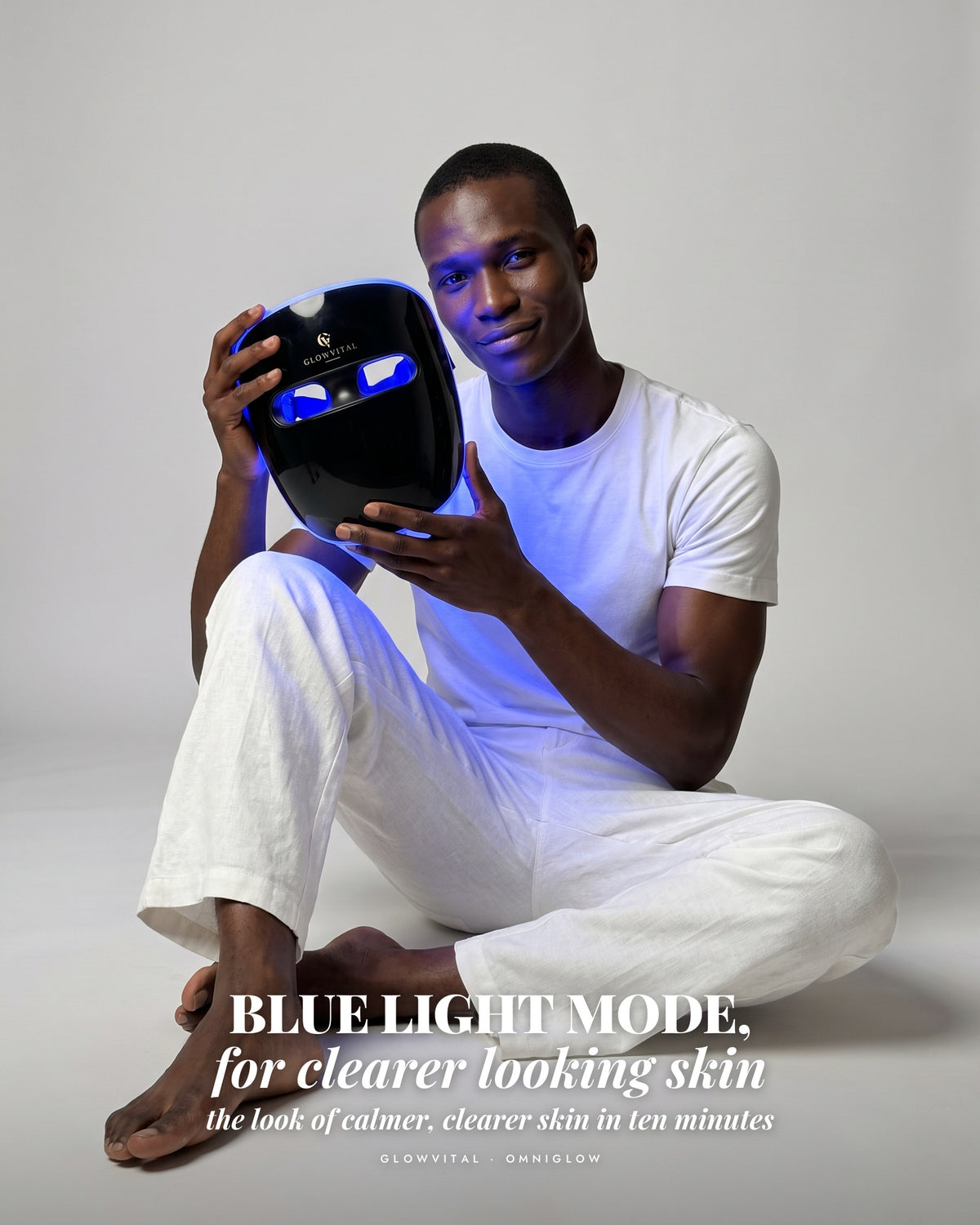 Man holding the OmniGlow mask glowing blue
