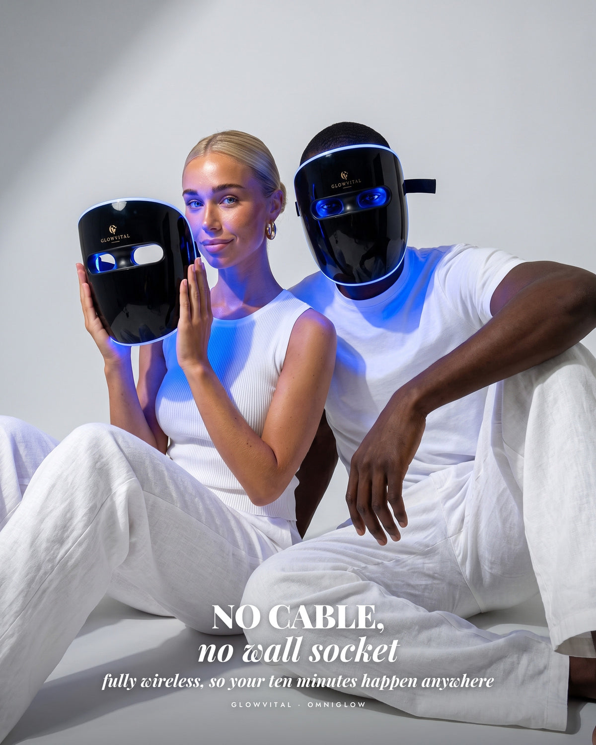 Two people in blue light, one wearing the cordless OmniGlow mask