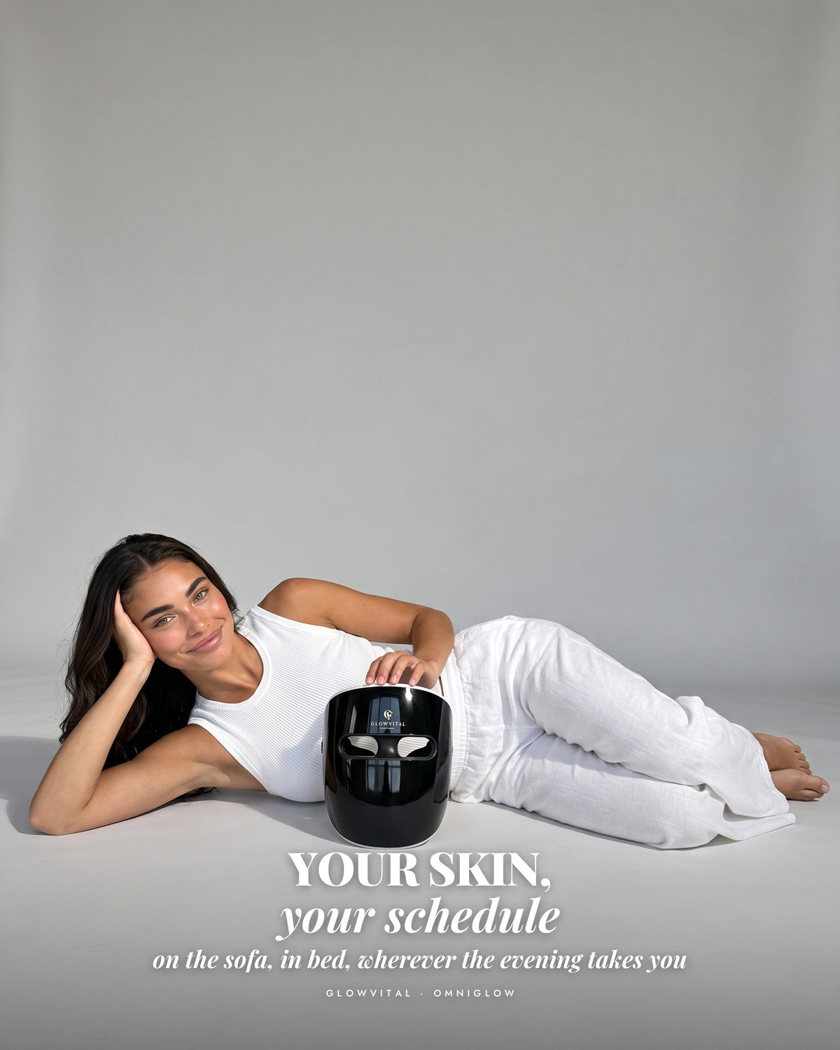 Woman lying on her side beside the OmniGlow mask